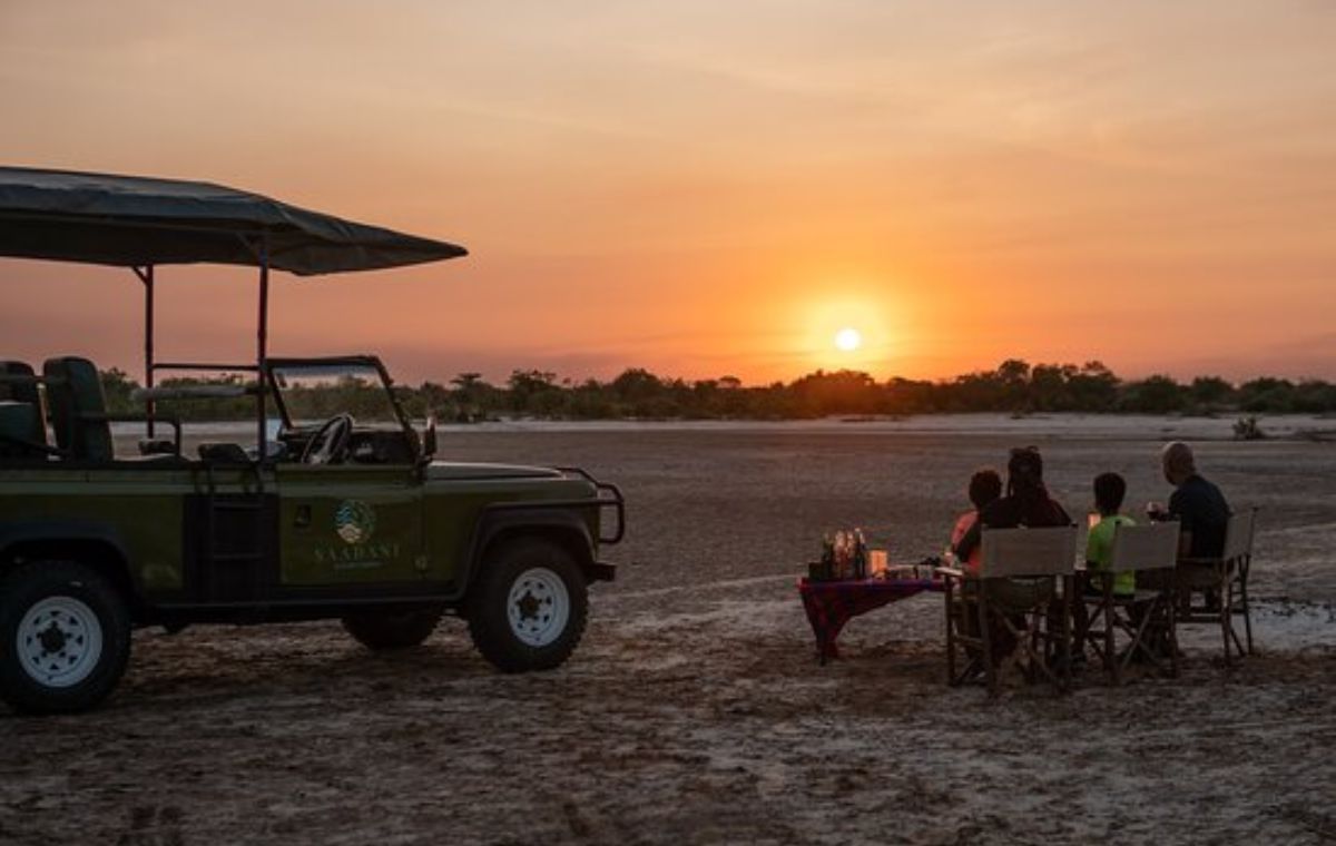 Couple and children watching sunset from a private safari vehicle in Saadani National Park
